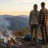 A traditional couple standing together in a rugged outdoor setting.