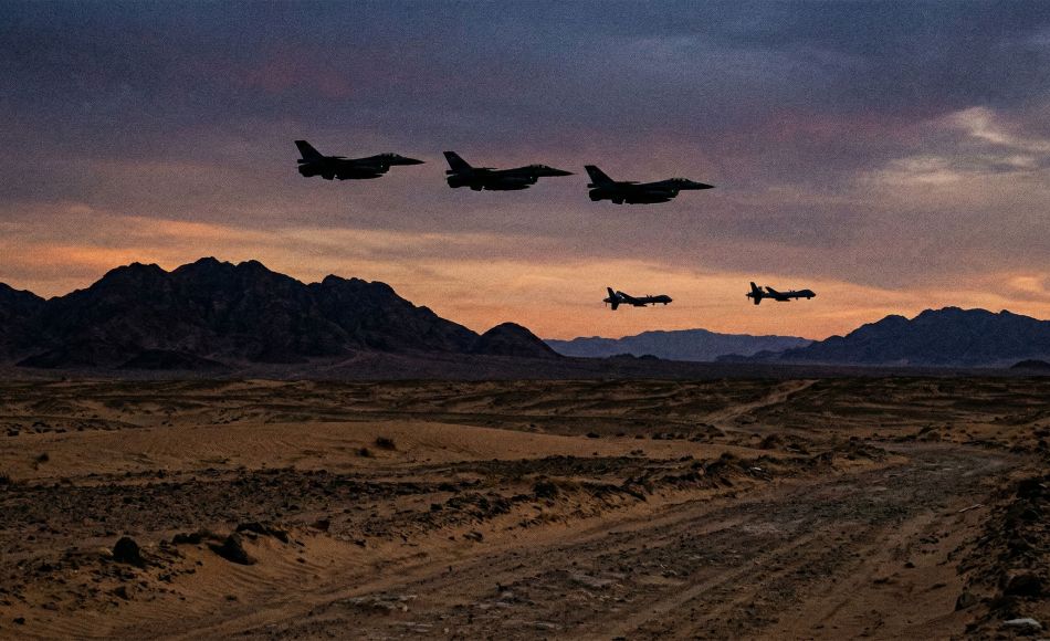 Military aircraft flying over a desert landscape during a strategic operation.