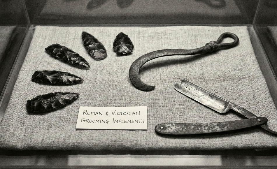 A collection of traditional and modern male grooming tools including a straight razor and safety razor.