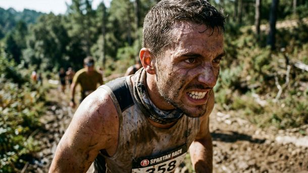 Homme concourant seul dans un défi physique exigeant, incarnant la pulsion brute et la réussite méritée