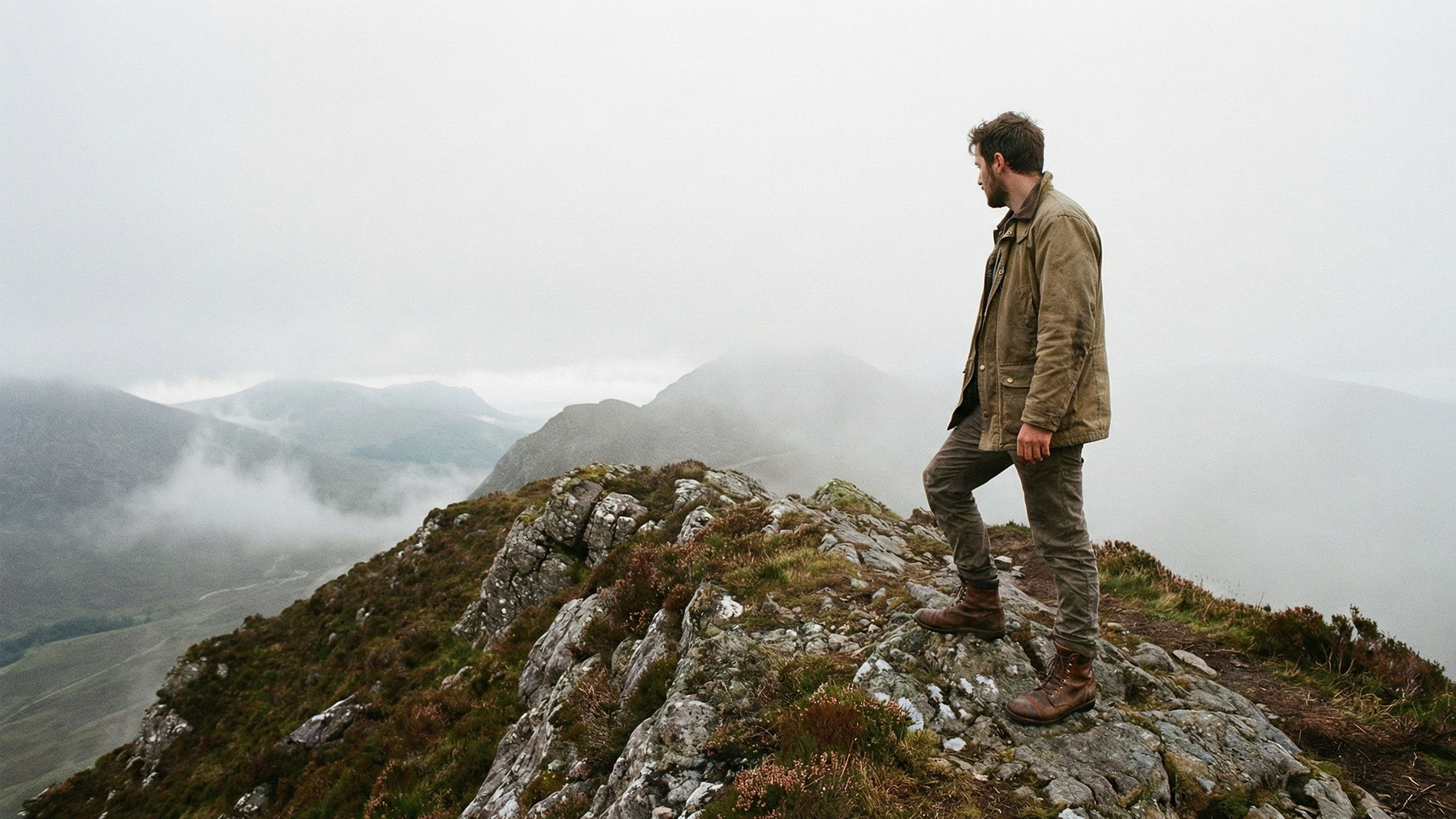 A man standing alone on a misty, jagged mountain ridge avoiding medical concerns.