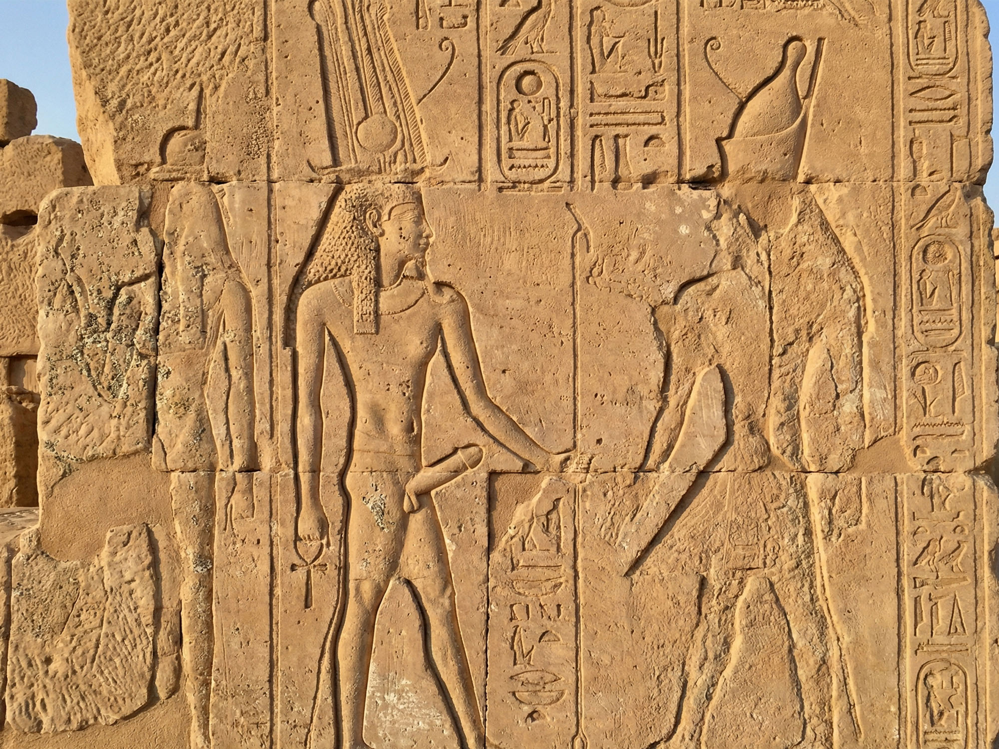 Tallados fálicos egipcios erosionados en piedra.