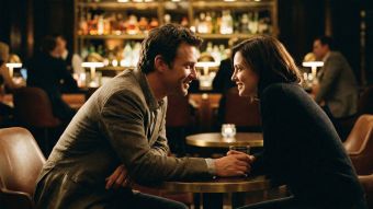 A man and woman engaged in a conversation at a bar showing positive body language.