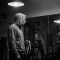 A man examining his reflection, symbolizing the pressure of male physical statistics.
