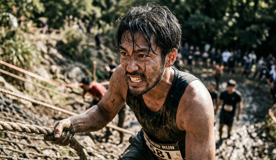 厳しい身体的挑戦に一人で挑む男性。生の駆動力と勝ち取った達成感を体現