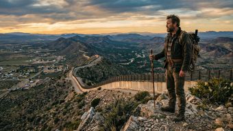 A man observing a national border, symbolizing the protection of sovereignty.