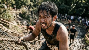 厳しい身体的挑戦に一人で挑む男性。生の駆動力と勝ち取った達成感を体現