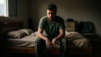 Homem sentado na beira da cama pela manhã refletindo sobre os efeitos do estresse e da falta de sono