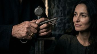 Les mains d’un homme serrant un symbole traditionnel d’héritage et de protection.