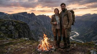 Ein traditionelles Paar steht gemeinsam in einer rauen Außenlandschaft.