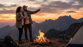 Um casal tradicional em pé juntos em um cenário natural e rústico.