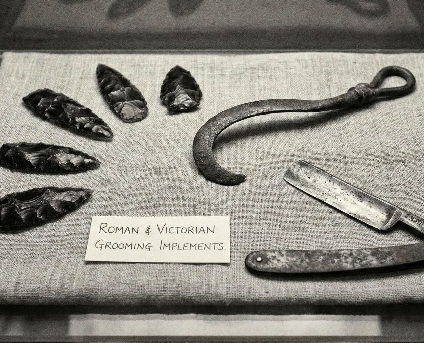 A collection of traditional and modern male grooming tools including a straight razor and safety razor.