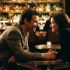 A man and woman engaged in a conversation at a bar showing positive body language.