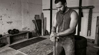 Un hombre enfocado en fuerza funcional en un entorno rudo.