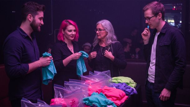 Men and women at a pheromone party smelling T-shirts and meeting through scent-based matchmaking.