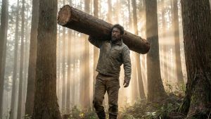 自然の中で重い荷物を運び、機能的な力を示す男性。