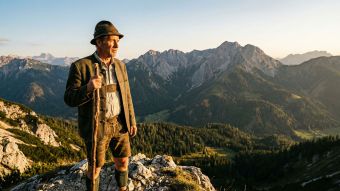 Ein starker Mann mit Blick über eine Gebirgskette als Sinnbild traditioneller männlicher Virilität und der Versorgerrolle.