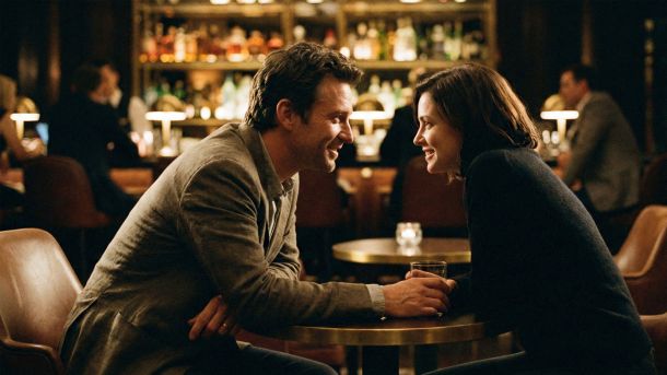 A man and woman engaged in a conversation at a bar showing positive body language.
