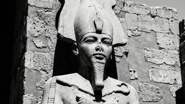 Escultura em pedra de uma divindade antiga representando força e potência masculina.