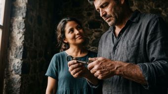 Las manos de un hombre sosteniendo un símbolo tradicional de herencia y protección.