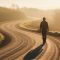 Man walking winding road at dawn for masculine journey reflection