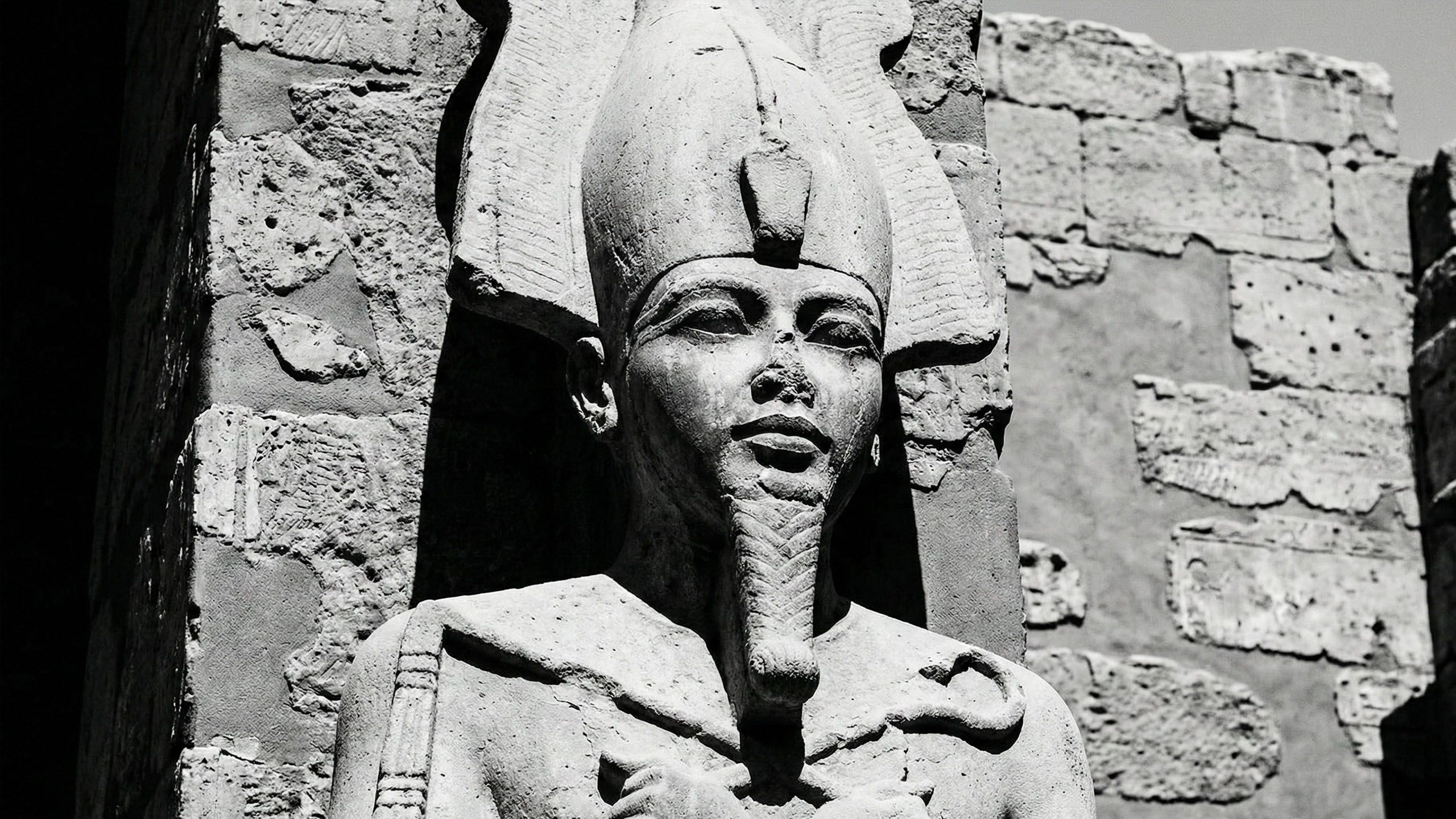 Escultura em pedra de uma divindade antiga representando força e potência masculina.