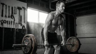 Mature man performing a heavy deadlift to maintain muscle mass and bone density.